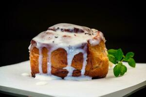 cocido horneado dulce cinnabon con crema en horneando papel . foto