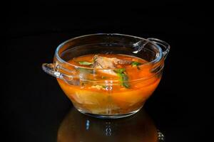 vegetal tomate sopa con pescado en un plato foto