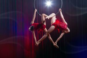 Circus actress acrobat performance. Two girls perform acrobatic elements in the air ring. photo