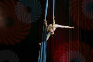 circo artista acróbata actuación en lienzos el niña realizar acrobático elementos en el aire. foto