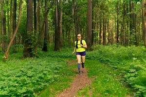 woman jogging on a trail in a natural forest park photo