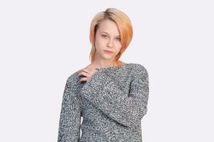 girl teenager in a sweater looks into the frame isolated on a white background photo