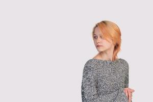 girl teenager in a knitted sweater looks back isolated on a white background photo