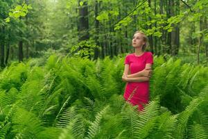 niña adolescente caminando en el bosque entre helechos foto