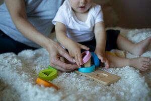 little boy plays with young beautiful mom in the bedroom photo