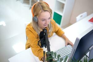 young woman is streaming while sitting in coworking at the computer photo