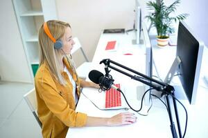 young woman is streaming while sitting in coworking at the computer photo