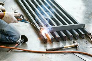 Industrial worker welding steel with sparks photo