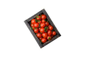 Fresh red cherry tomatoes in a wooden vintage box photo