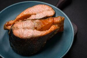 Fresh cooked delicious salmon steak with spices and herbs baked on a grill photo