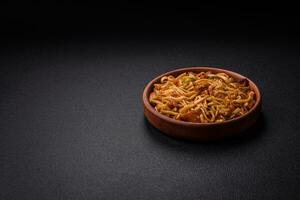 Delicious asian udon dish with vegetables, mushrooms, salt and spices photo