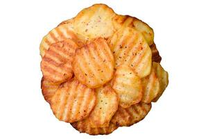 Delicious crispy fried potatoes in slices on a black ceramic plate photo