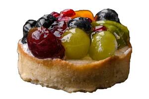 Delicious fresh tart with blueberries, cherries, grapes on a black ceramic plate photo