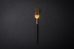 Kitchen fork made of steel on a dark textured background photo