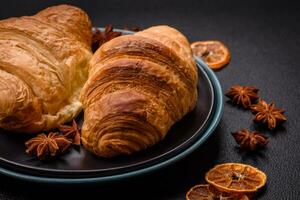 Delicious crispy baked sweet croissants with filling on a ceramic plate photo