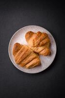 delicioso crujiente horneado dulce croissants con relleno en un cerámico plato foto