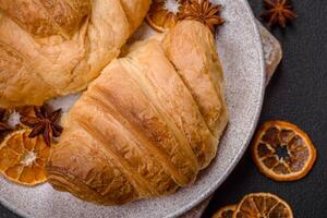 Delicious crispy baked sweet croissants with filling on a ceramic plate photo