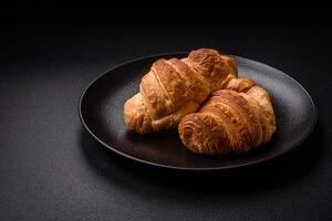 Delicious crispy baked sweet croissants with filling on a ceramic plate photo