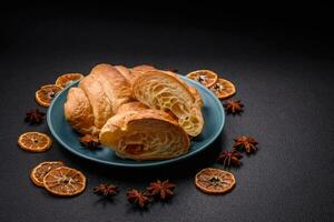 Delicious crispy baked sweet croissants with filling on a ceramic plate photo