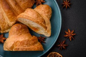 Delicious crispy baked sweet croissants with filling on a ceramic plate photo