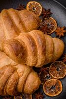 Delicious crispy baked sweet croissants with filling on a ceramic plate photo