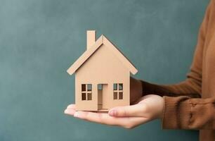 AI generated child holds paper cardboard house after moving in to a new home photo