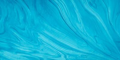 blue liquid paint on a surface with waves photo