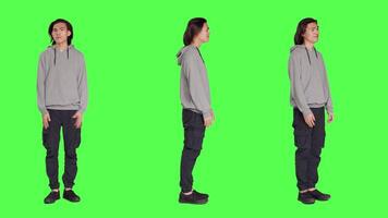 Young unsure guy shrugging on camera, doing i dont know sign after hearing question. Model feeling clueless and uncertain over full body greenscreen backdropground, doubtful person. video