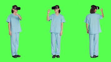 Operating with advanced 3d glasses, medical staff uses virtual reality headset against greenscreen background. Artificial intelligence utilized by healthcare professional specialist. video