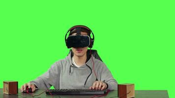 POV of person playing vr videogames sitting at desk over greenscreen backdrop, going online with friends enjoying rpg gameplay. Young adult using virtual reality headset, gaming. video