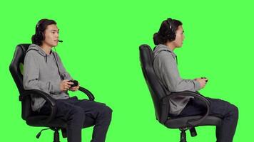 Gamer having fun with rpg challenge over greenscreen background, playing videogames with controller. Young asian guy enjoying online gaming, video game player with coordination skill.