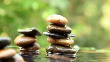 Stack of Balanced rocks pyramid on water with Golden light natural peace concepts bokeh on background video