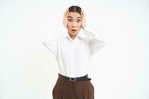 Businesswoman holds hands on head in panic, faces disaster, feels complicated and pressured, white background photo