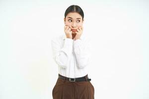 Worried young asian corporate woman, office lady looks anxous and unsure aside, white background photo