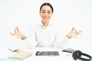 Worplace and working environment. Young woman sits in office with tablet and documents, keeps calm, meditates and smiles, relaxes, white background photo