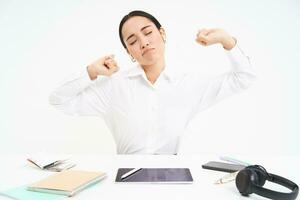 Tired businesswoman in office, sits back and stretches hands, exhausted after work, white background photo