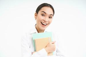 Portrait of businesswoman with notebooks, teacher laughing and smiling, standing over white studio background photo