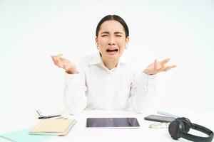 triste japonés oficina gerente, mujer gritando y gritos, estresado fuera en trabajar, se sienta en oficina con afligido emociones, blanco antecedentes foto