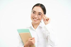 Smiling woman professional, asian female teacher with glasses, looking confident, standing over white background photo