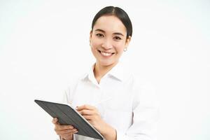 Portrait of businesswoman working on digital tablet, creating diagrams for meeting conference on gadget, standing over white background photo