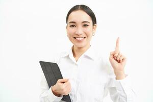 Corporate asian woman, manager using digital tablet, working on gadget, checking charts, company statistics, standing over white background photo