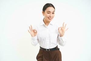 Business. Professional businesswoman, shows okay, approval gesture, recommends smth, white studio background photo