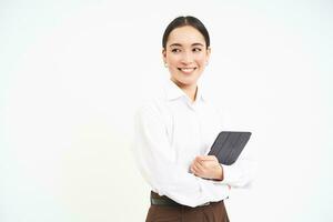asiático mujer profesional, en pie con digital tableta, trabajando en proyecto, escritura abajo notas para negocio reunión, en pie aislado terminado blanco antecedentes foto