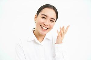 Beautiful young korean woman, laughing and smiling, showing sincere happiness and joy, standing over white background photo