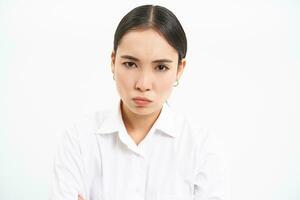 corporativo gente. grave y confidente asiático mujer de negocios, mirando estricto a empleado, en pie terminado blanco antecedentes foto