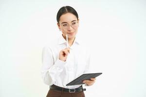 Beautiful asian woman, entrepreneur with digital tablet, working on business project, leading meeting and looking at notes on device, white background photo