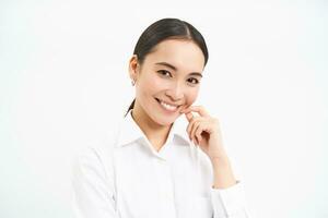 retrato de joven asiático mujer profesional, sonriente con confianza, profesional mirar, en pie terminado blanco antecedentes foto