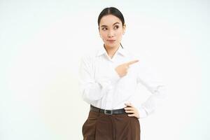 Skeptical lady boss, employer points finger right, looks with serious, confident face at banner, white background photo