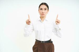 Image of female employee, office worker points finger at banner, shows promo advertisement on isolated white background photo