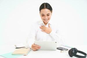 Image of saleswoman, asian entrepreneur talks on video chat from her office, has a meeting, connects to webinar online, white background photo